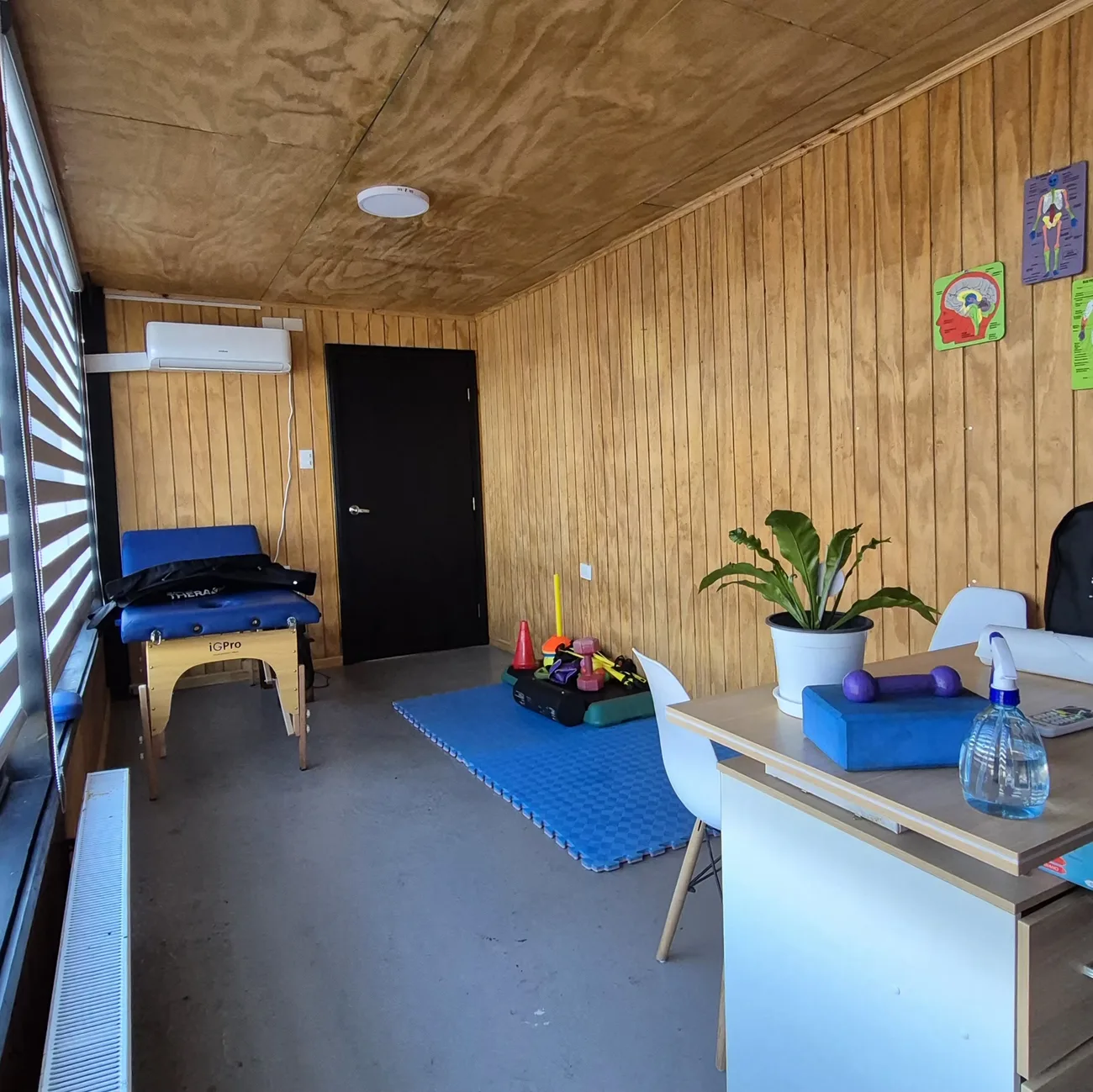 Sala de kinesiología con camilla y equipamiento de rehabilitación